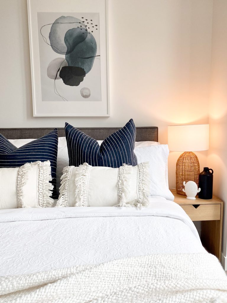 Bedroom with navy and white. Neutral styling bedroom with abstract art. 