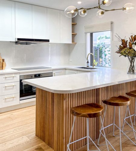 large brass and glass pendant over kitchen island