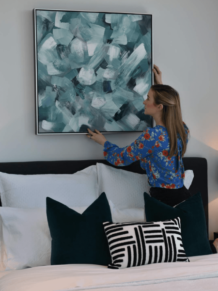 hanging artwork over a bed